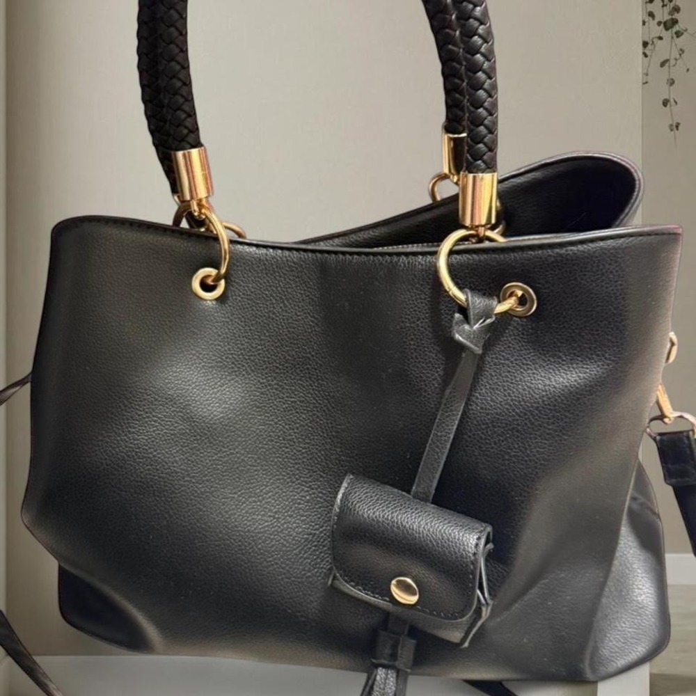 Black faux leather crossbody bag with gold hardware, featuring a zipper